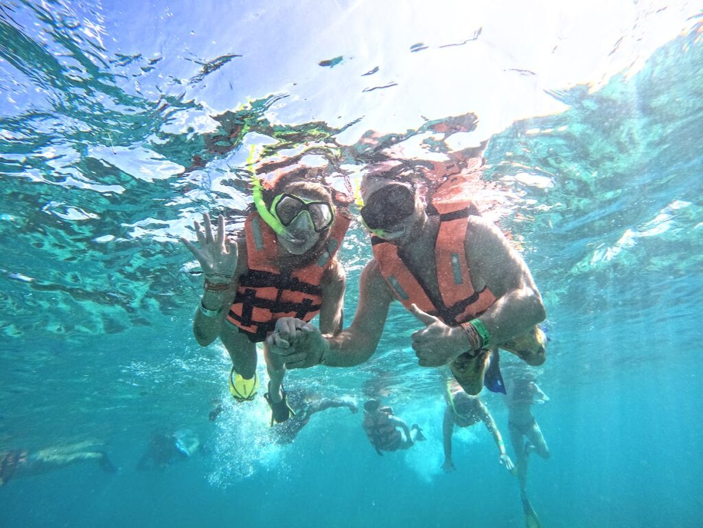 Us snorkeling and smiling at the camera underwater