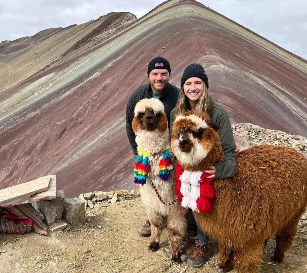Standing with the alpacas in front of Rainbow Mountain