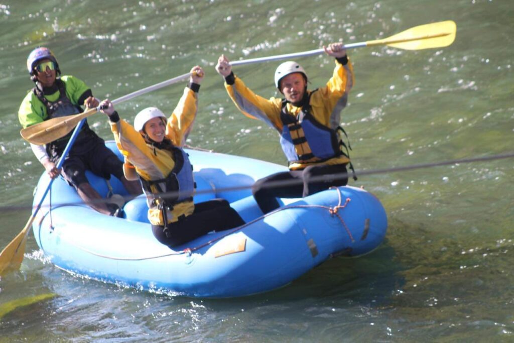 Riding in the raft and holding up the paddles