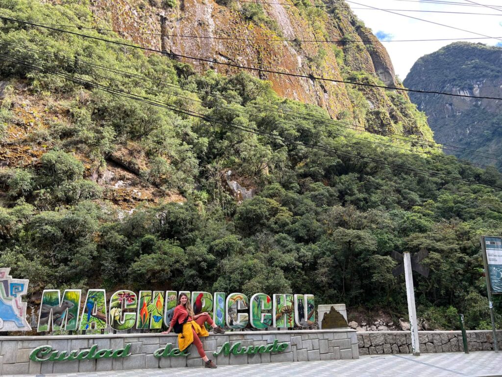 Sitting at the colorful Machu Picchu Sign