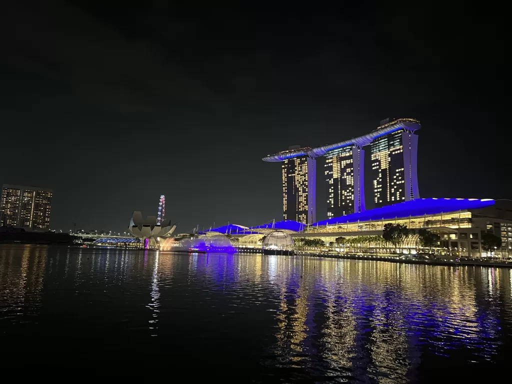 Marina Bay Sands lit up at night during the Spectra Light Show from across the river