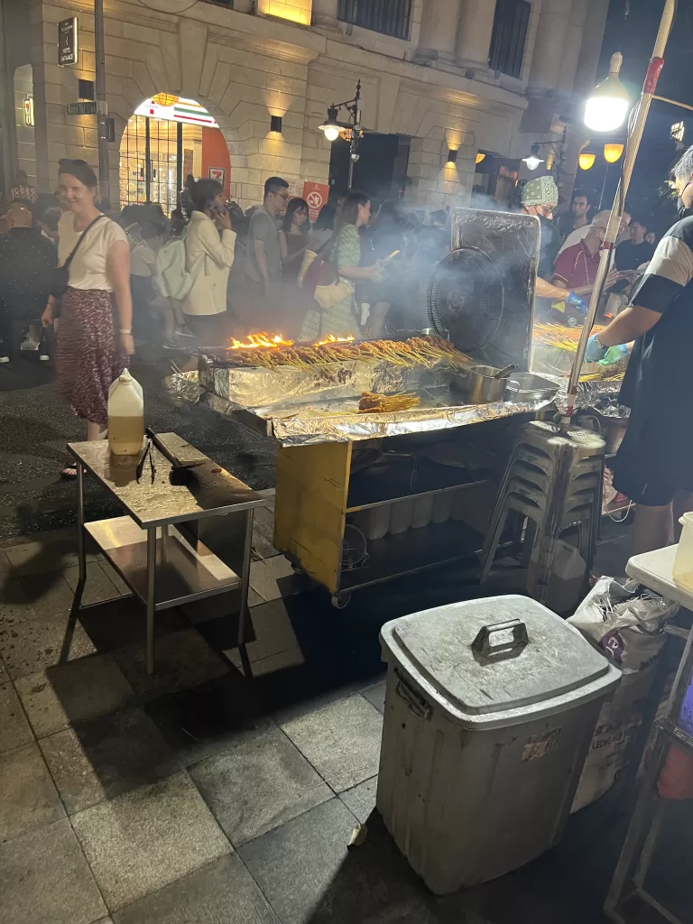 Stall at Satay Street with different Satay cooking on the open grill. 