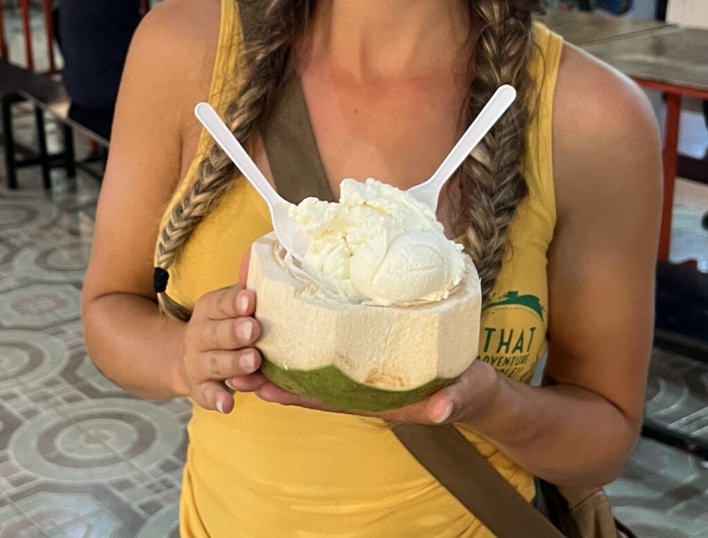 Coconut ice cream with two spoons in a fresh green coconut